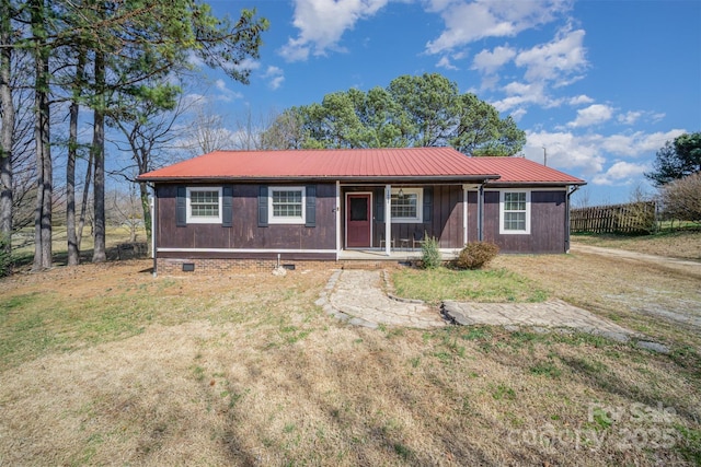 single story home featuring a porch, a front yard, crawl space, and metal roof