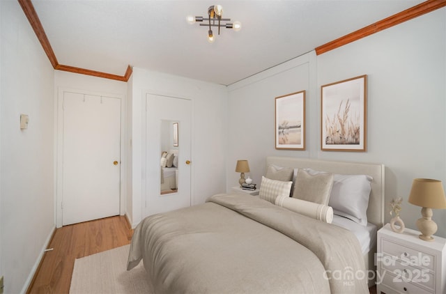 bedroom featuring a closet, ornamental molding, and wood finished floors