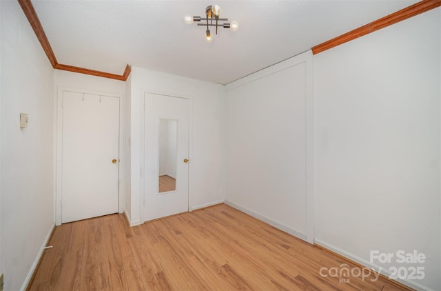 spare room featuring crown molding and wood finished floors