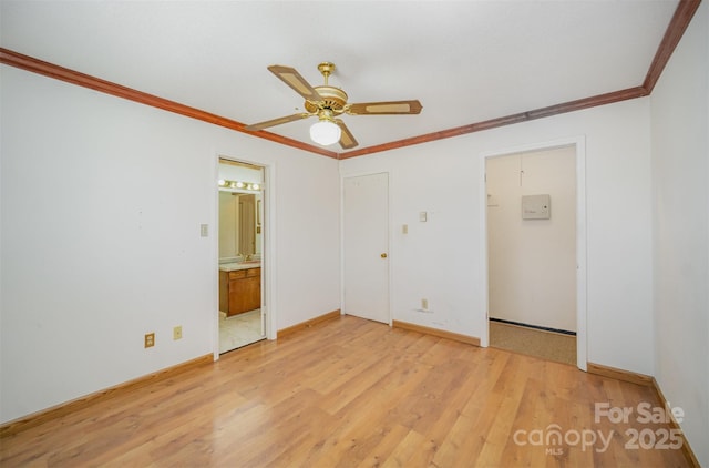 unfurnished bedroom featuring light wood finished floors, baseboards, ensuite bath, ornamental molding, and a closet