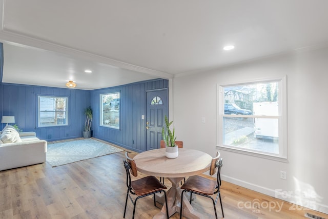 dining area with a wealth of natural light, light wood-style flooring, and baseboards