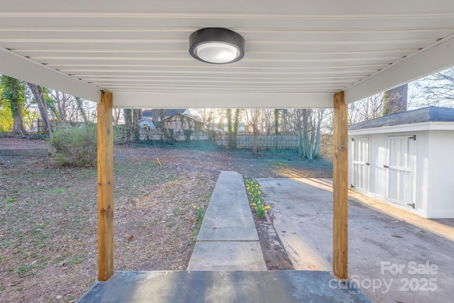 view of yard featuring a patio area, fence, an outdoor structure, and a storage shed