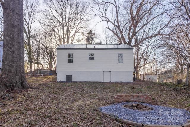 exterior space with metal roof and central AC unit