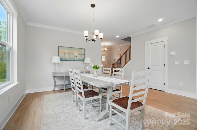 dining area with crown molding, light wood-type flooring, and visible vents
