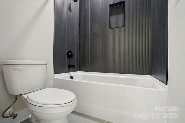 bathroom with tile patterned flooring, tub / shower combination, and toilet