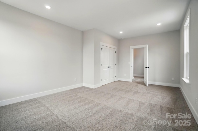 unfurnished bedroom featuring carpet flooring, recessed lighting, baseboards, and a closet