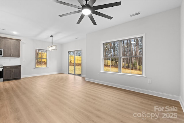 unfurnished living room with light wood-type flooring, baseboards, and visible vents