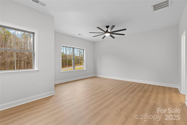 empty room with light wood-style floors, visible vents, ceiling fan, and baseboards