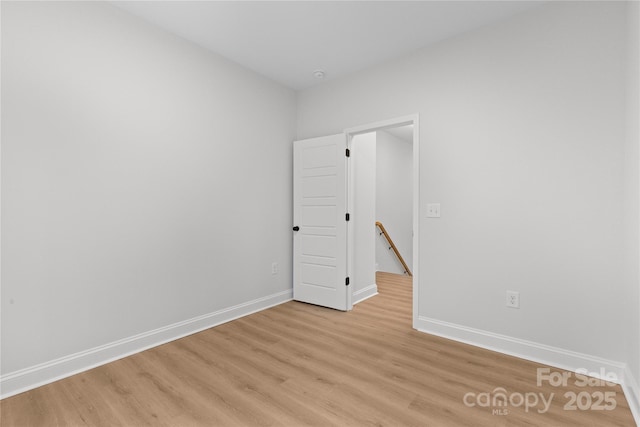 spare room with light wood-type flooring and baseboards