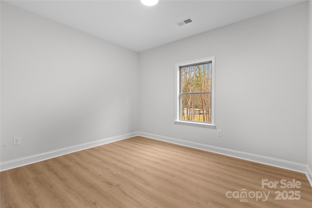 empty room with light wood-style flooring and baseboards