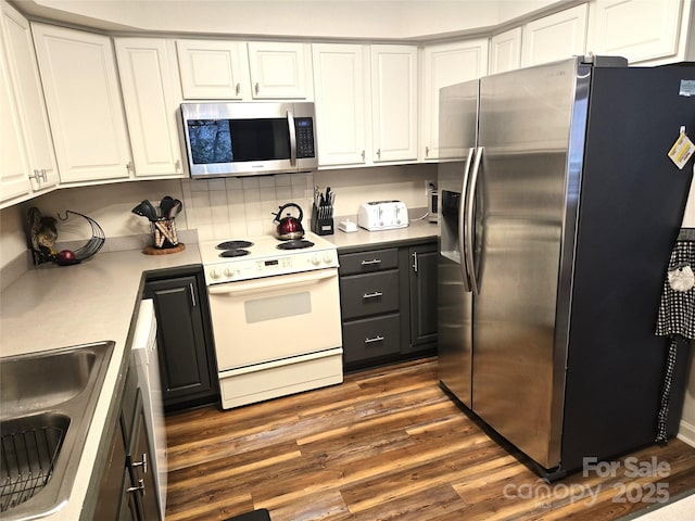 kitchen with white cabinets, stainless steel appliances, dark wood-style flooring, and light countertops