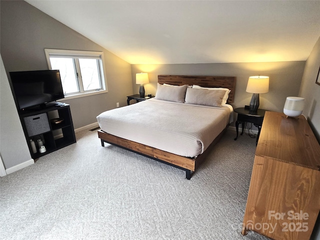 bedroom with lofted ceiling, carpet flooring, and baseboards