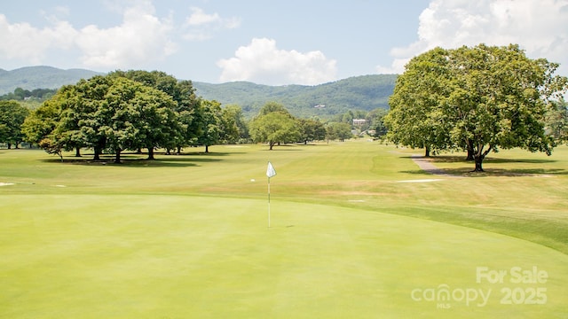 view of property's community featuring a mountain view, golf course view, and a lawn