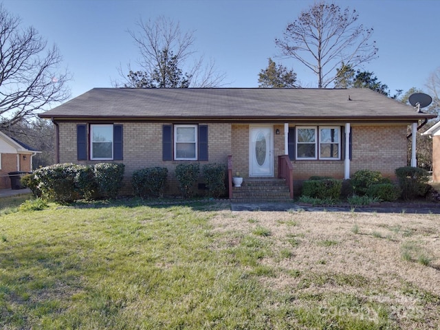 single story home with entry steps, a front lawn, and brick siding