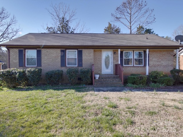 ranch-style home featuring entry steps, brick siding, and a front lawn