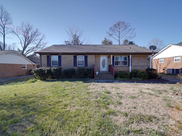 ranch-style home featuring brick siding, a front lawn, and central AC unit