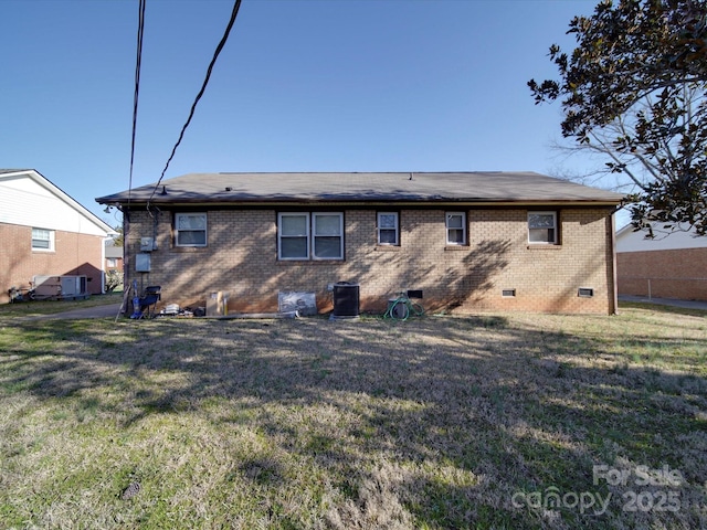 rear view of property featuring a yard, central AC, brick siding, and crawl space