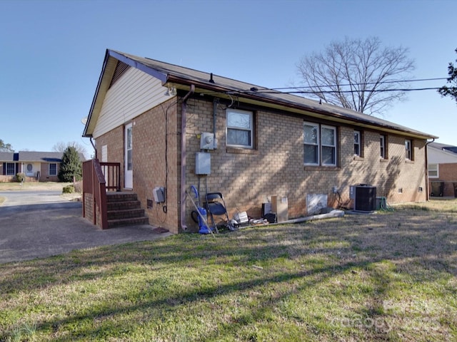 back of property featuring central air condition unit, a yard, crawl space, and brick siding