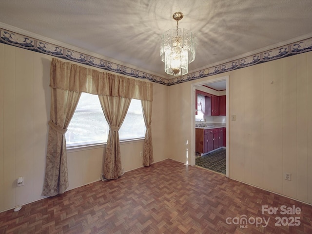 unfurnished room with parquet floors, a textured ceiling, and a notable chandelier