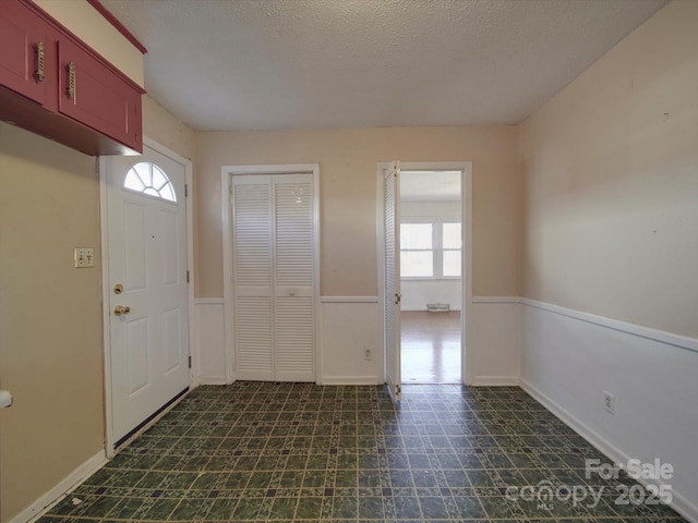 entrance foyer featuring dark floors and a textured ceiling