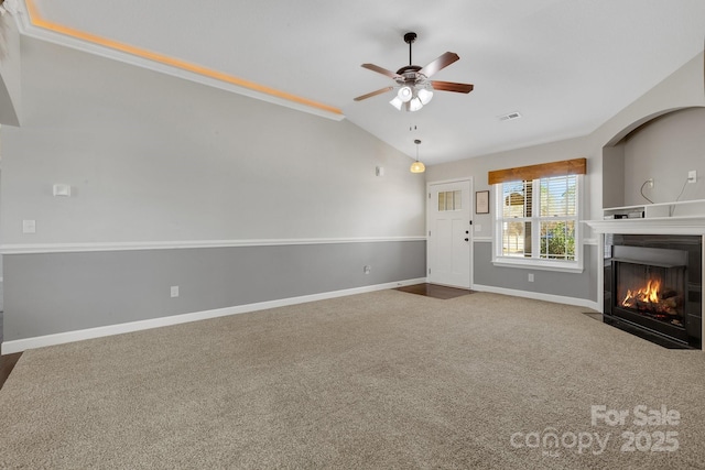 unfurnished living room with visible vents, baseboards, lofted ceiling, a fireplace with flush hearth, and carpet