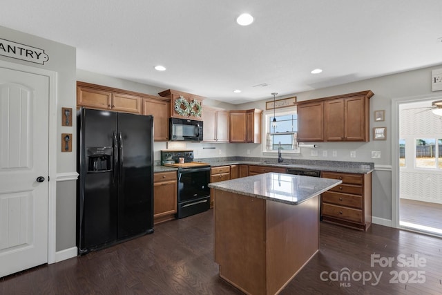 kitchen featuring brown cabinetry, dark wood-style flooring, and black appliances