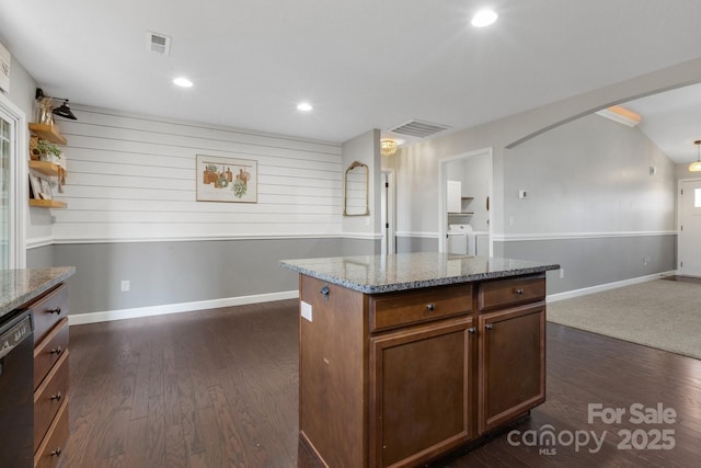 kitchen with washing machine and dryer, visible vents, dishwasher, and arched walkways