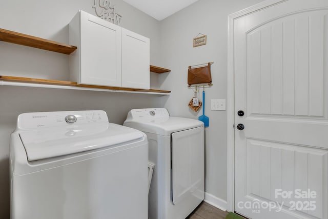 washroom with washer and dryer, cabinet space, and baseboards