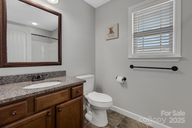 bathroom featuring toilet, tile patterned flooring, vanity, and baseboards