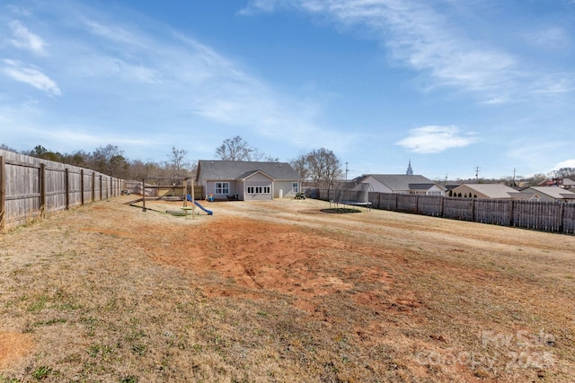 view of yard featuring a playground and a fenced backyard