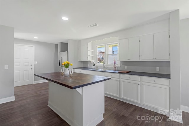 kitchen featuring white cabinets, visible vents, a sink, and stainless steel refrigerator with ice dispenser