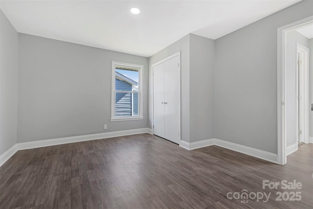 empty room with baseboards and wood finished floors