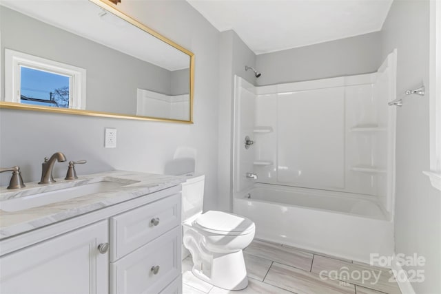 bathroom featuring shower / bathing tub combination, vanity, and toilet