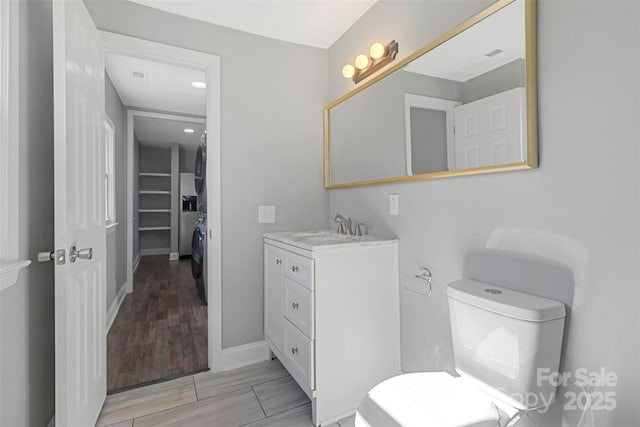 bathroom featuring toilet, visible vents, vanity, and baseboards