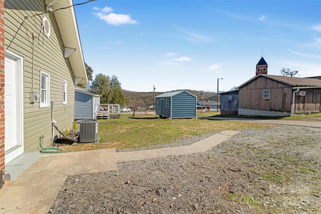 view of yard with an outbuilding and central air condition unit