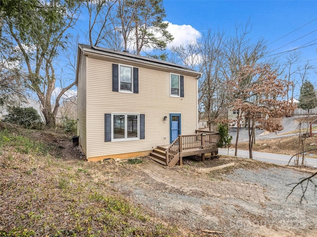 view of front of house with solar panels and a wooden deck