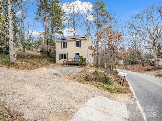 view of front facade featuring driveway and a deck