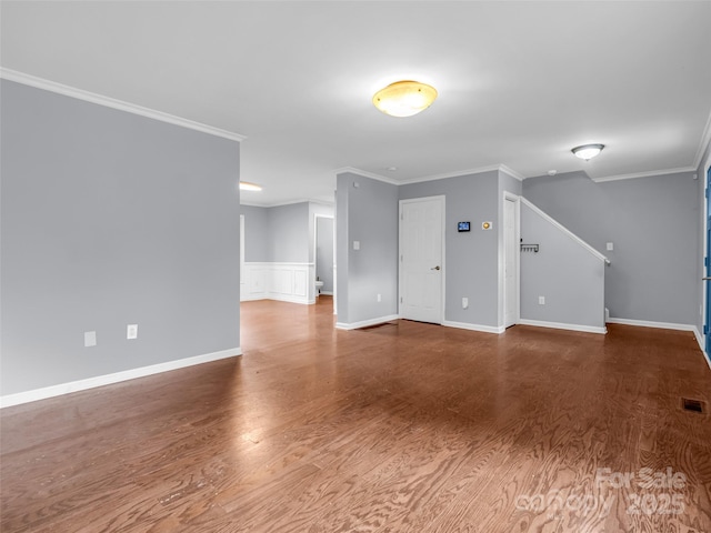 unfurnished living room with ornamental molding, wood finished floors, visible vents, and baseboards