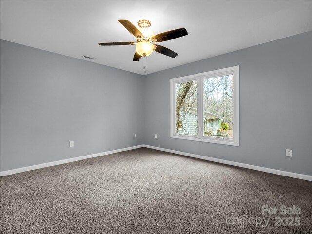 carpeted empty room featuring visible vents, ceiling fan, and baseboards