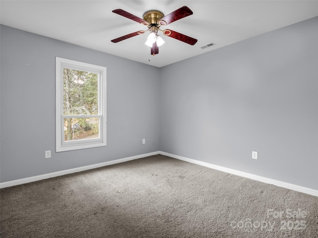 carpeted empty room featuring visible vents, ceiling fan, and baseboards