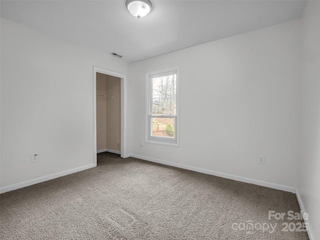 unfurnished bedroom featuring a closet, carpet flooring, visible vents, and baseboards