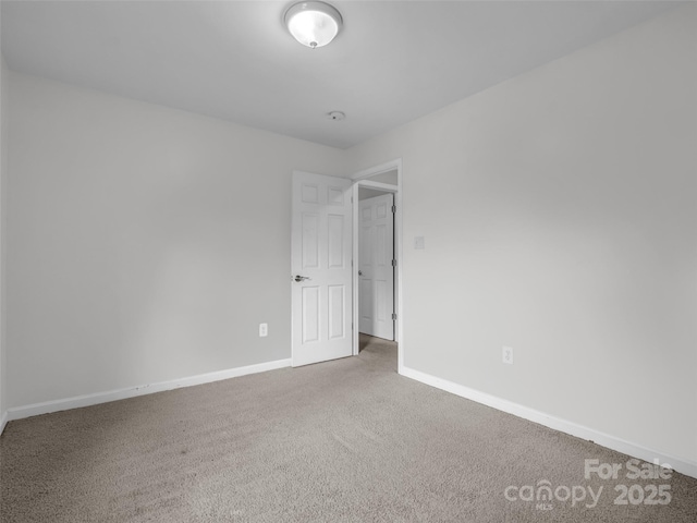 empty room featuring baseboards and carpet flooring