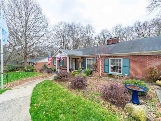 single story home featuring a front yard, brick siding, and a chimney