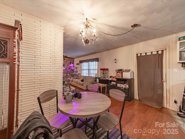 dining area featuring wood finished floors and an inviting chandelier