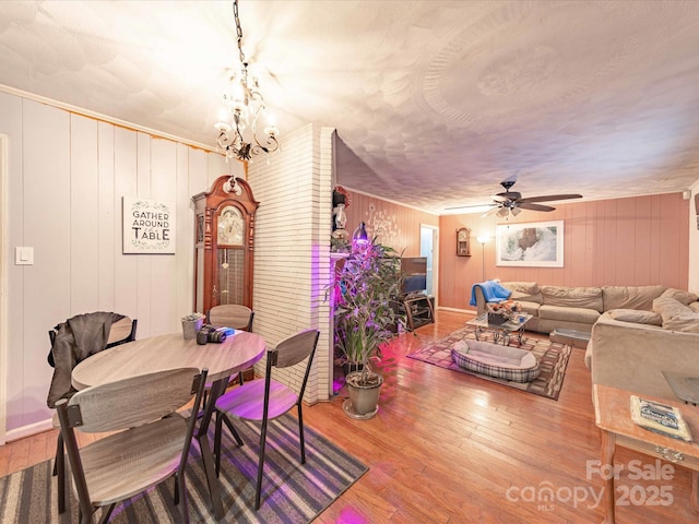 dining room featuring ceiling fan with notable chandelier and wood finished floors