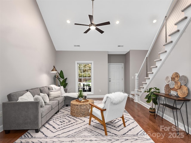 living area with visible vents, stairway, a ceiling fan, wood finished floors, and baseboards