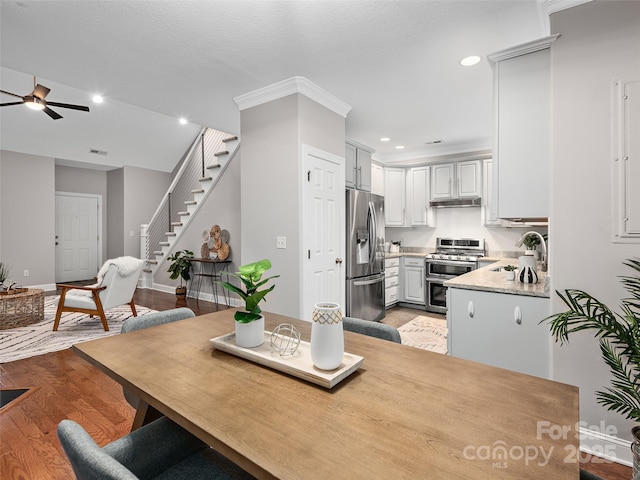 dining space featuring baseboards, ceiling fan, stairs, light wood-style floors, and recessed lighting