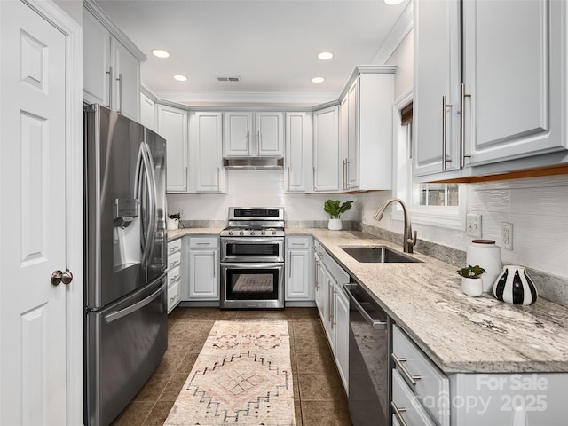 kitchen with light stone counters, stainless steel appliances, recessed lighting, a sink, and under cabinet range hood