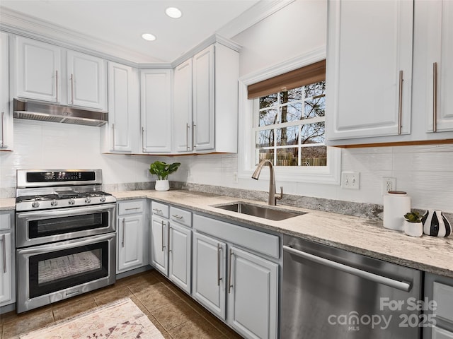 kitchen featuring stainless steel appliances, backsplash, a sink, and under cabinet range hood