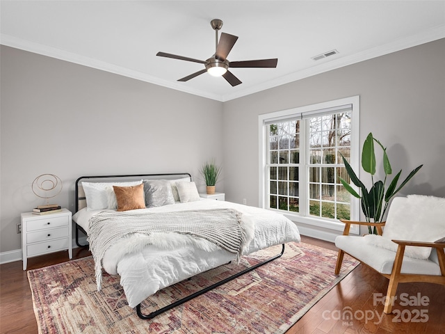 bedroom with baseboards, visible vents, wood finished floors, and ornamental molding